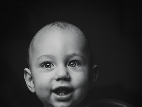 Ein Schwarz-Weiß-Foto von einem Baby mit zwei Zähnen.