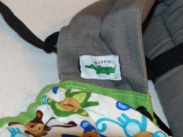 Das Buzzidil. Eine Detailaufnahme des Logos, auf dem ein Krokodil zu sehen ist, der einen Babykrokodil trägt.