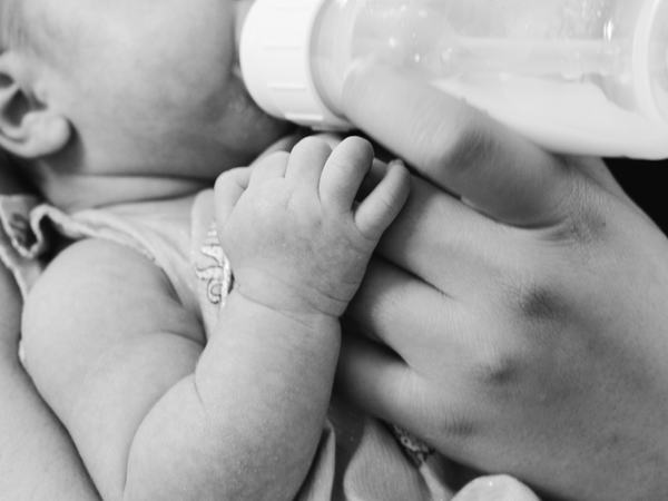 Aufnahme eines Babys, welches mit der Flasche gefüttert wird.