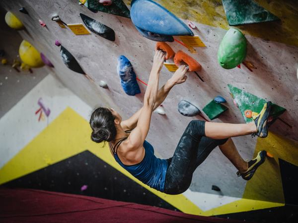 Aufnahme einer Frau, welche gerade bouldert.