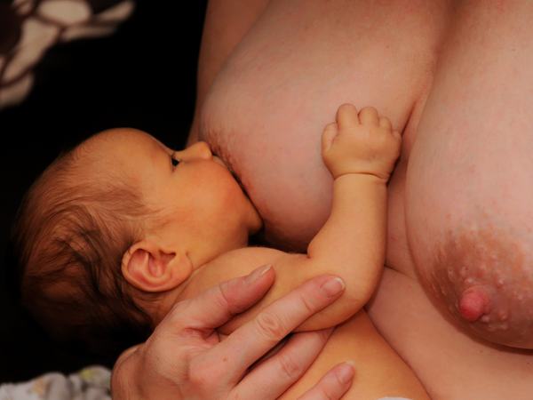 Aufnahme einer Frau mit Baby, welches gerade stillt.