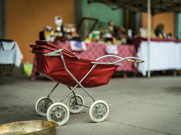 Ein roter altertümlicher Kinderwagen.