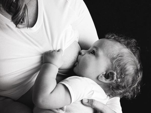 Aufnahme eines Babys, welches an der Brust stillt.