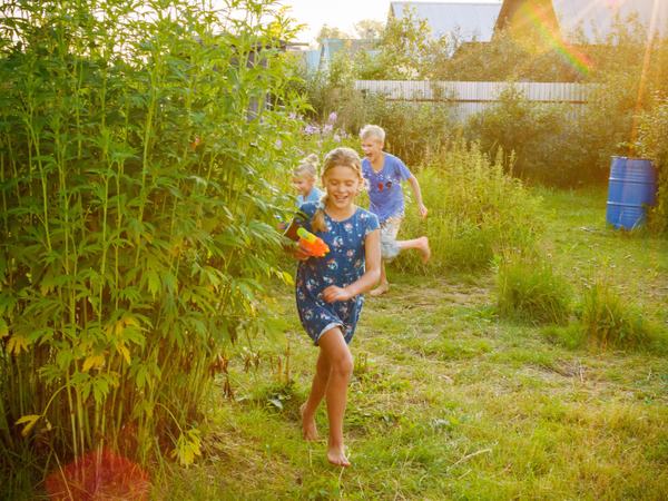 Aufnahme von mit Wasser spielenden Kindern im Garten.