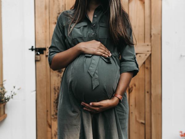 Teilaufnahme einer Frau mit Babybauch.