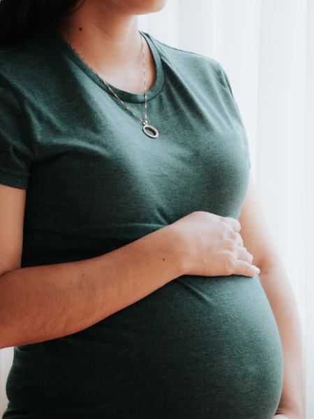 Eine weitere Teilaufnahme einer Frau mit Babybauch.