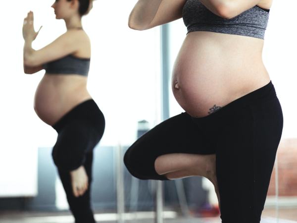 Aufnahme einer schwangeren Frau, die eine Yogaübung macht.