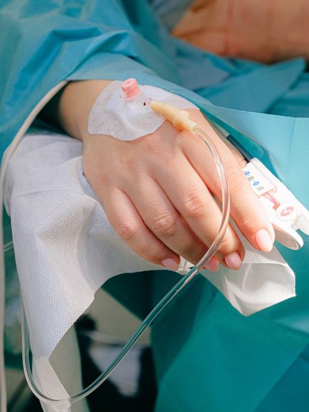 Detailaufnahme eines intravenösen Zugangs an der Hand.