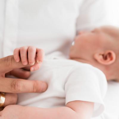 Eine Hand, die einen Babyfuß berührt.