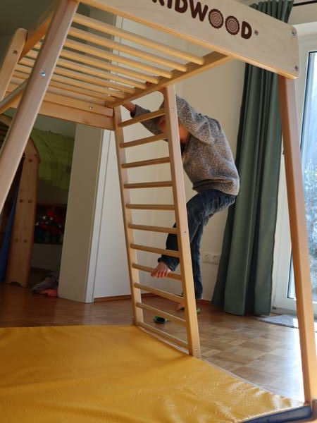 Mein Sohn klettert an der Leiter nach oben.