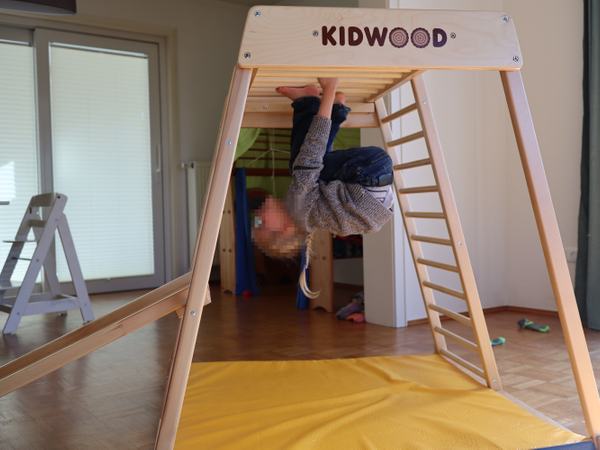 Mein Sohn klettert unten am Klettergerüst.