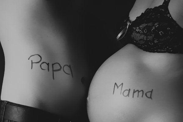 Ein schwarz-weiß Foto meines Schwangerschaftbauch mit der Aufschrift Mama und der Bauch meines Partners mit der Aufschrift Papa.