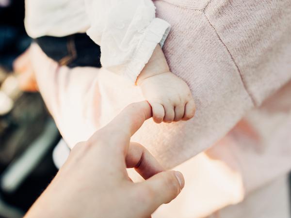 Eine Kinderhand wird von der Mutterhand gehalten.