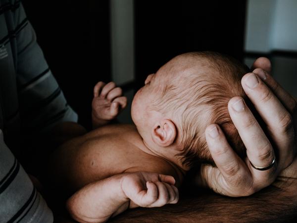 Aufnahme eines Babys in Händen gehalten