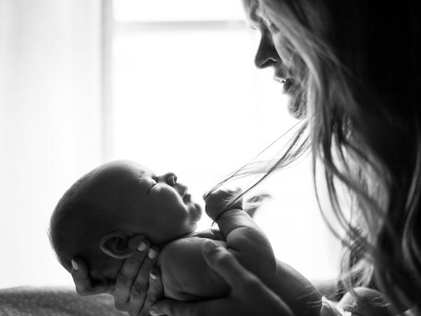 schwarz-weiß Aufnahme eines Baby in Händen gehalten