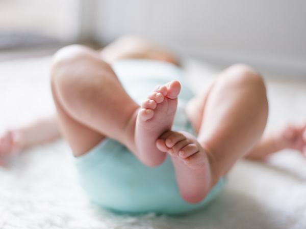 Aufnahme eines Babys von unten, sodass in erster Linie die Füße zu sehen sind.