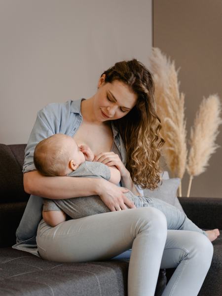 Eine Frau stillt ein größeres Baby in der Wiegeposition.