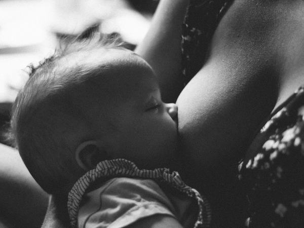 Ein Baby stillt an der Brust.