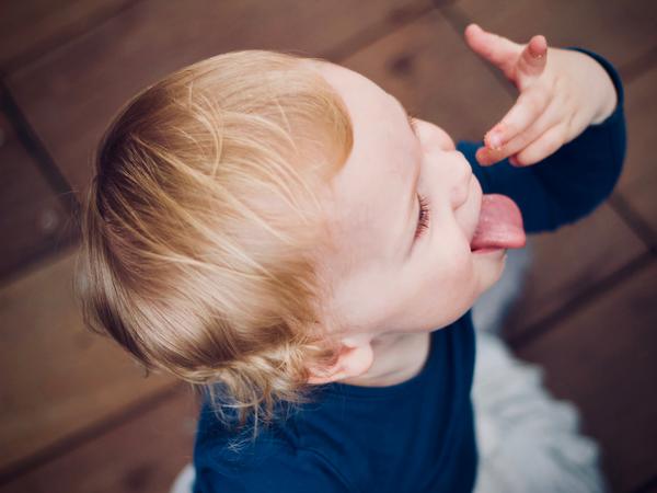Ein Kind streckt seine Zunge heraus.