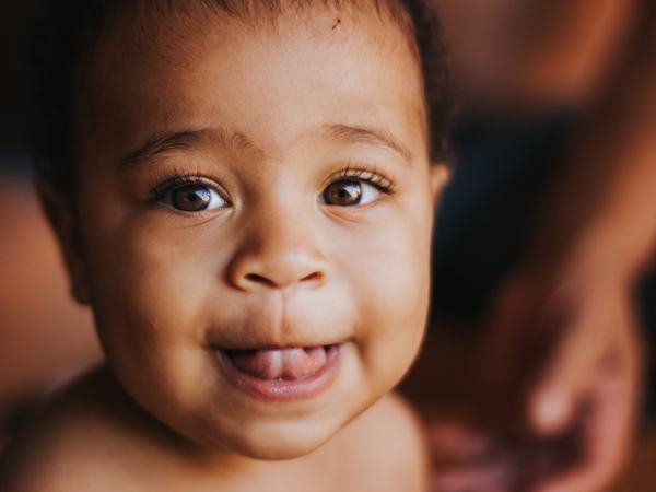 Aufnahme eines Baby, welches die Zunge innen gegen die obere Kauleiste drückt.