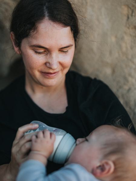 Aufnahme einer Mutter, die ihrem Baby die Milchflasche füttert.