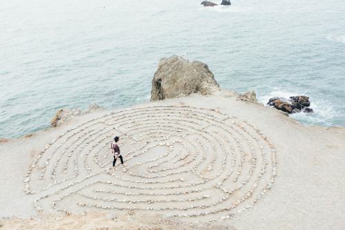 Eine Frau läuft auf ein metaphorisches Labyrinth zu.