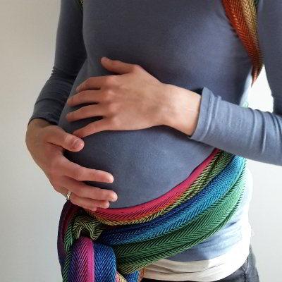 Eine schwangere Frau hält sich den Babybauch.